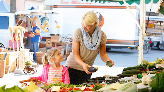 Frau mit Mädchen an einem Gemüsestand auf dem Markt von Maintal, Eckhard Stein für Maintal-Werke